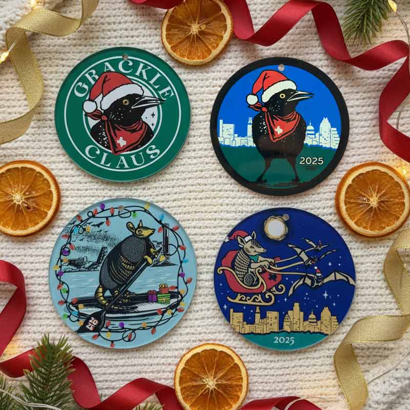 Four Christmas-themed ornaments with festive designs on a textured surface with orange slices and ribbons.