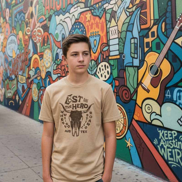 Person wearing a 'Lost in the Herd' t-shirt in front of a colorful mural.