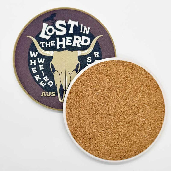 Cork coaster with 'Lost in the Herd' branded design on a white background