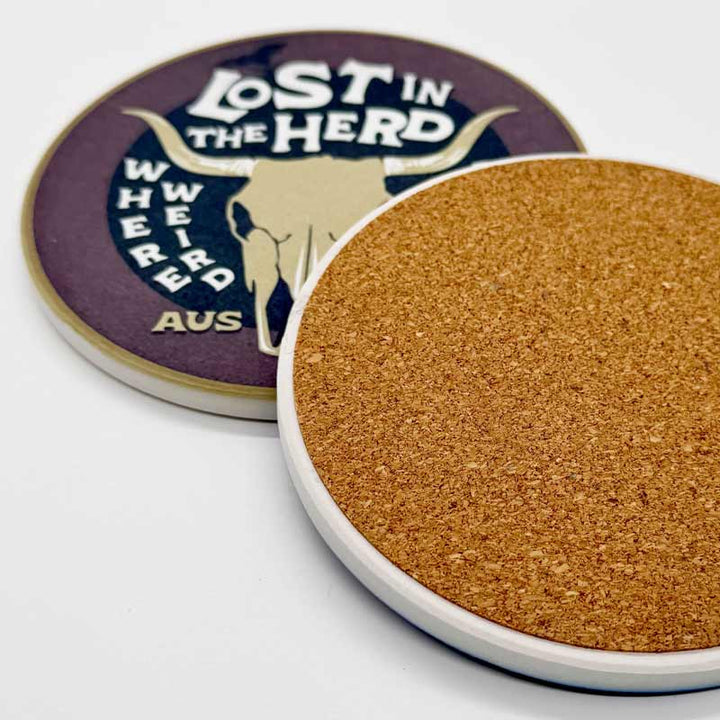 Coaster with cork back and 'Lost in the Herd' branding on a white background