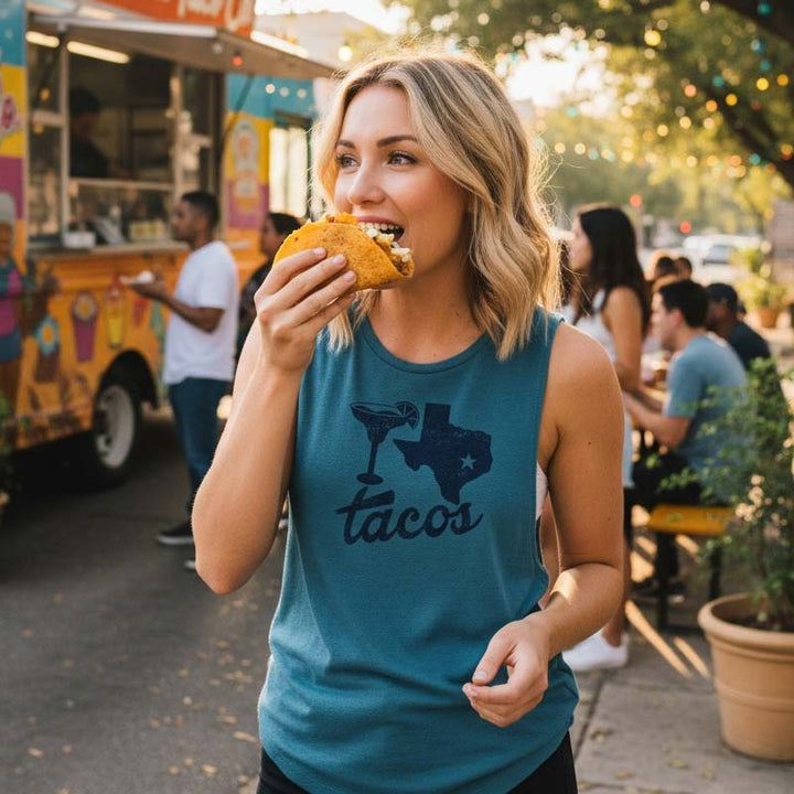Woman eating a taco outdoors with a food truck in the background