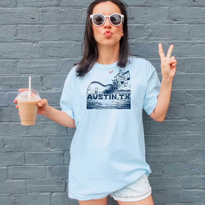 Model wearing ATX Music Bridge T-shirt, blending city skyline and live music theme