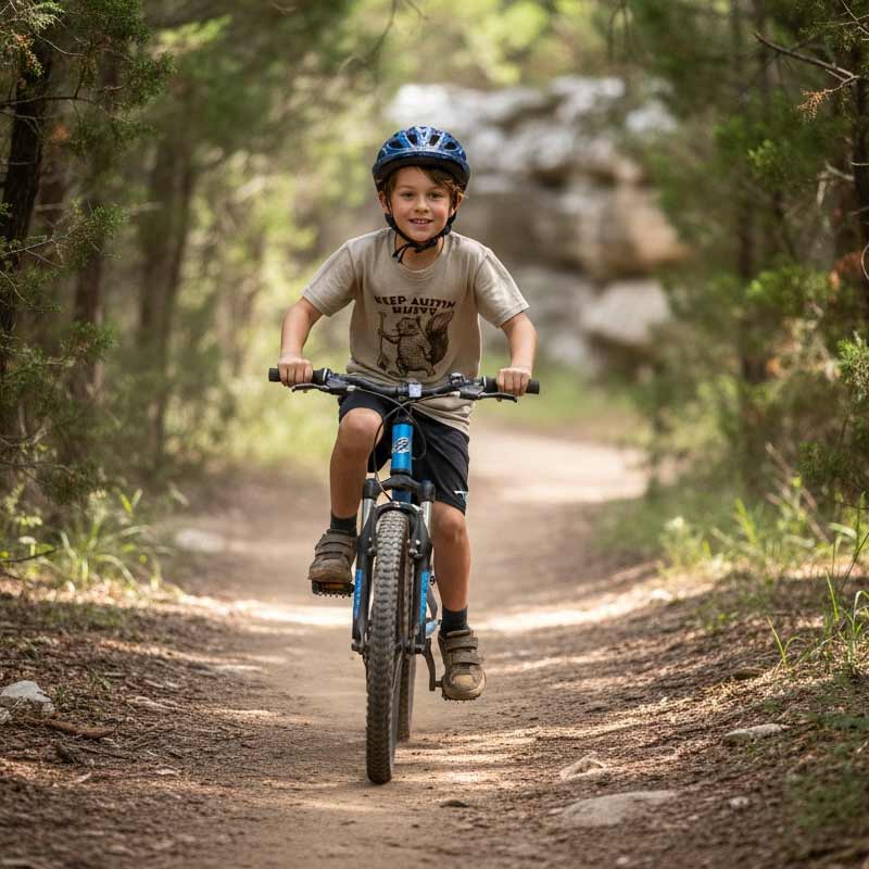 Child riding a bicycle on a forest trail with a helmet on