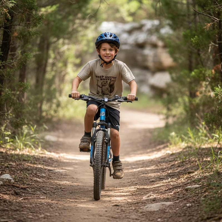 Child riding a bicycle on a forest trail with a helmet on