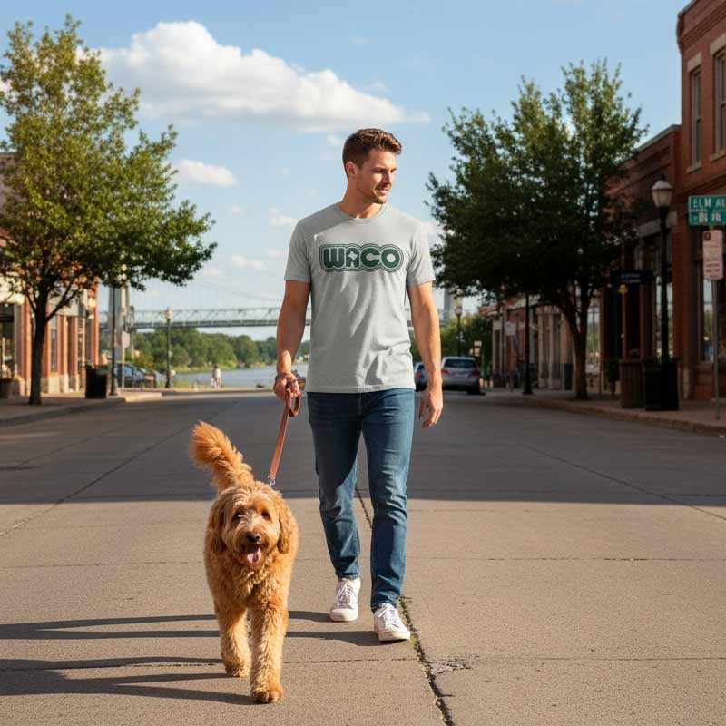 Man walking a dog on a leash in a town setting