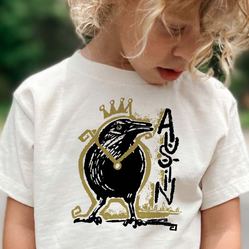 Toddler wearing Royal Squawk Austin t-shirt featuring a crown-wearing grackle – cute and fun ATX tee for kids