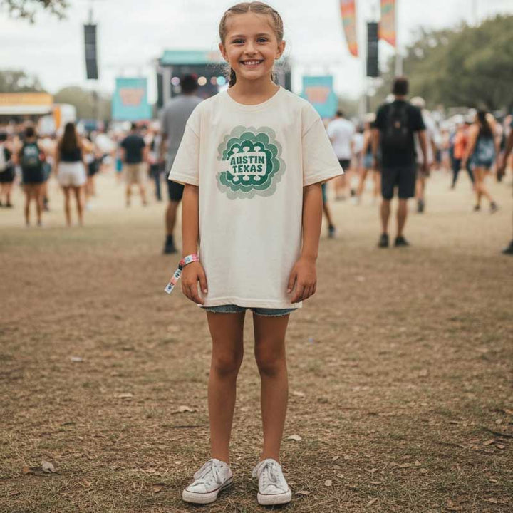 Child wearing a 'Austin Texas' t-shirt at a music festival.