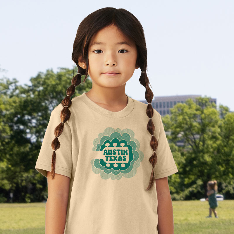 Model wearing our Sky Sync youth t-shirt with guitar neck rising into clouds – Austin music-themed tee for kids