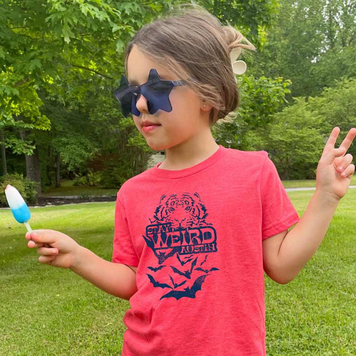 Model wearing our Stay Weird Austin youth t-shirt with bold, playful graphic – fun and quirky ATX tee for kids