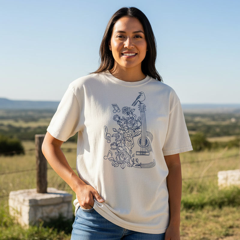 Woman wearing a white t-shirt with a graphic design in a scenic outdoor setting
