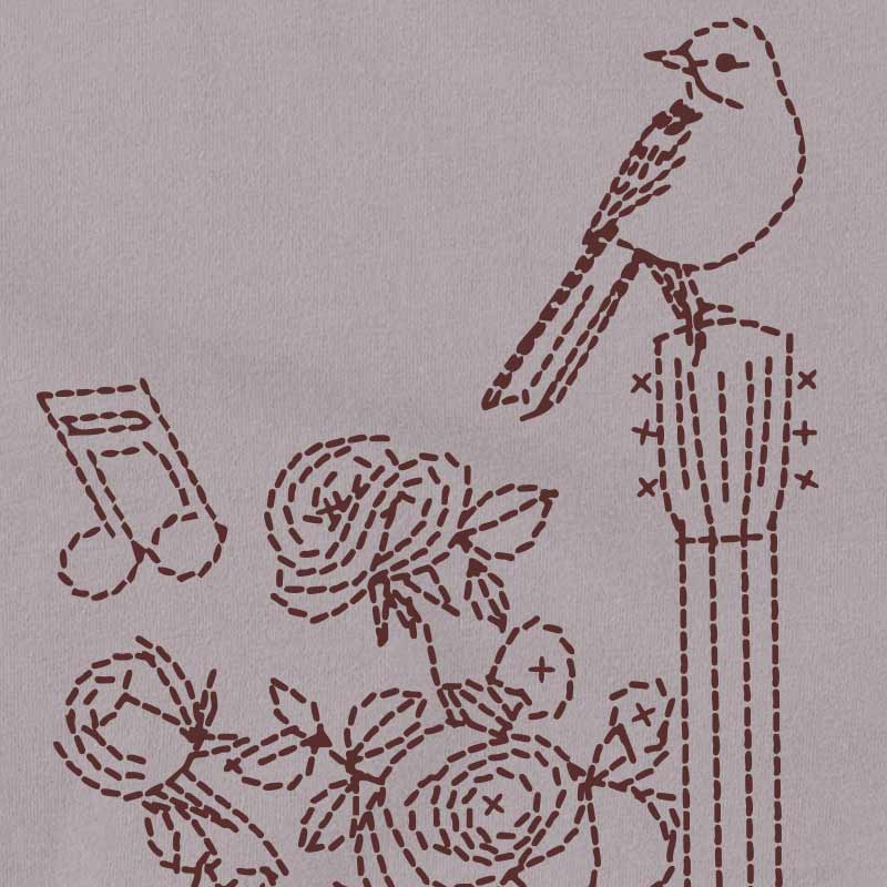 Embroidered design of a bird, flowers, and musical notes on a gray background