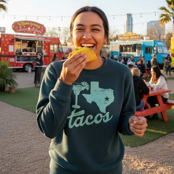 Woman eating a taco with food trucks in the background