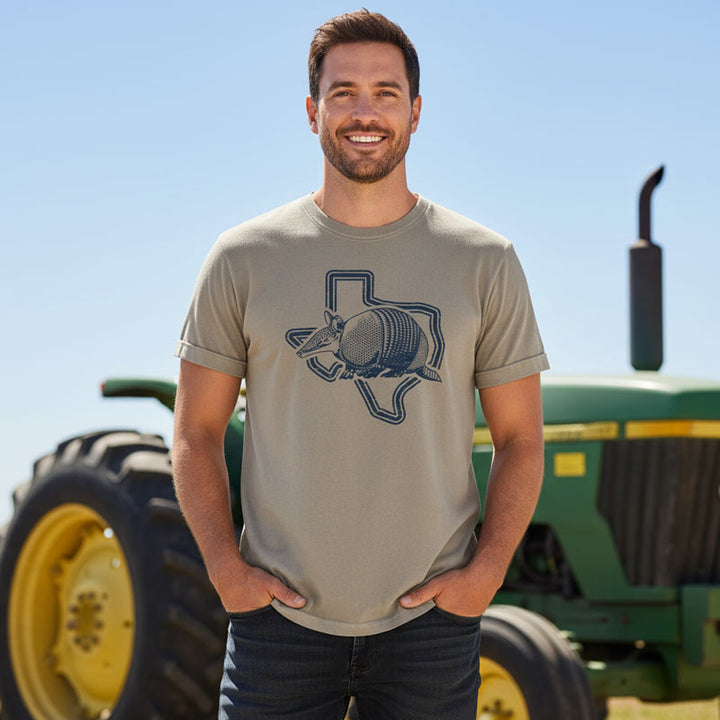 Man wearing a t-shirt with a graphic design in front of a tractor