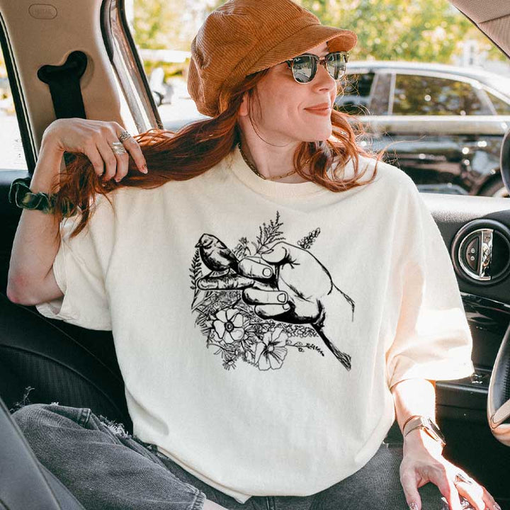 Person wearing rebellious bird graphic tee with floral design – funny and bold statement shirt