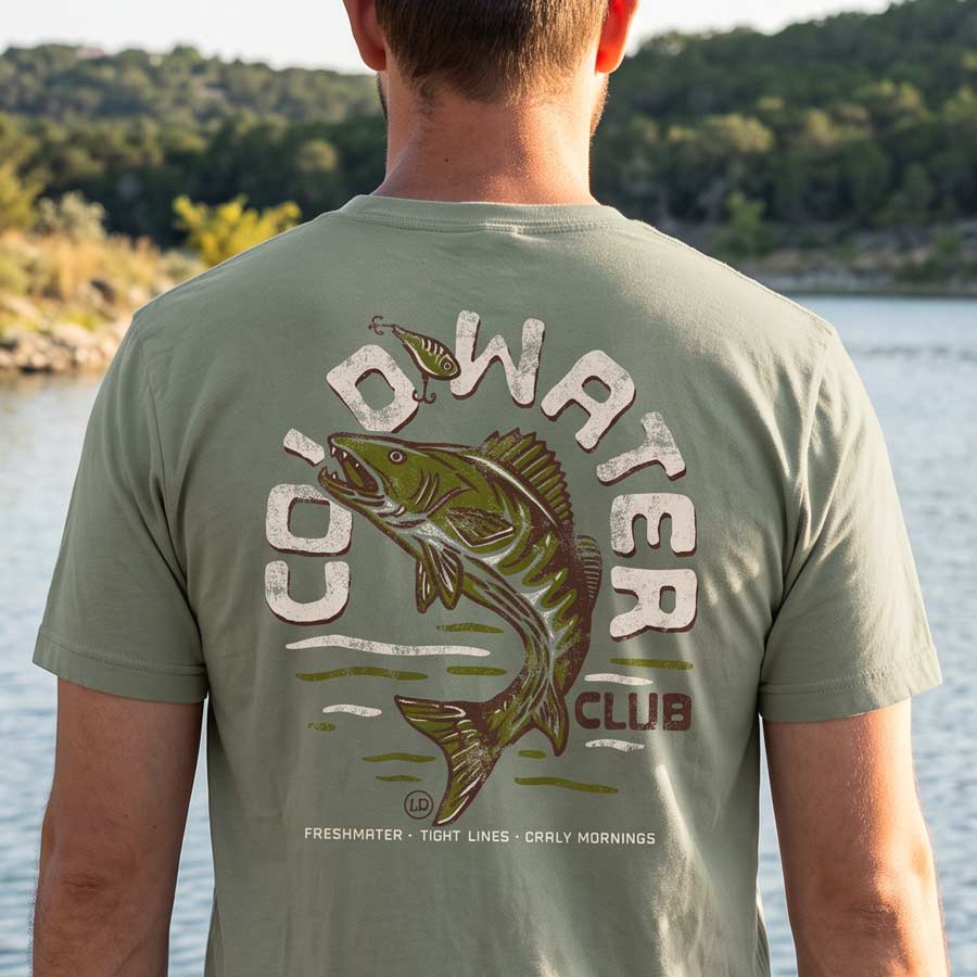 Man wearing Cold Water Club Tee while fishing, showing the large vintage walleye graphic on the back.