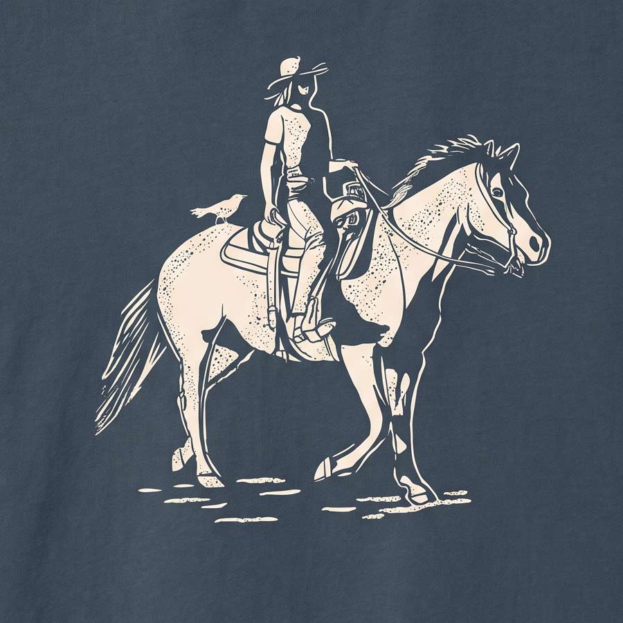 Close-up of the cream-colored cowgirl and horse illustration printed on the Vintage Navy Dust &amp; Reins Tee.