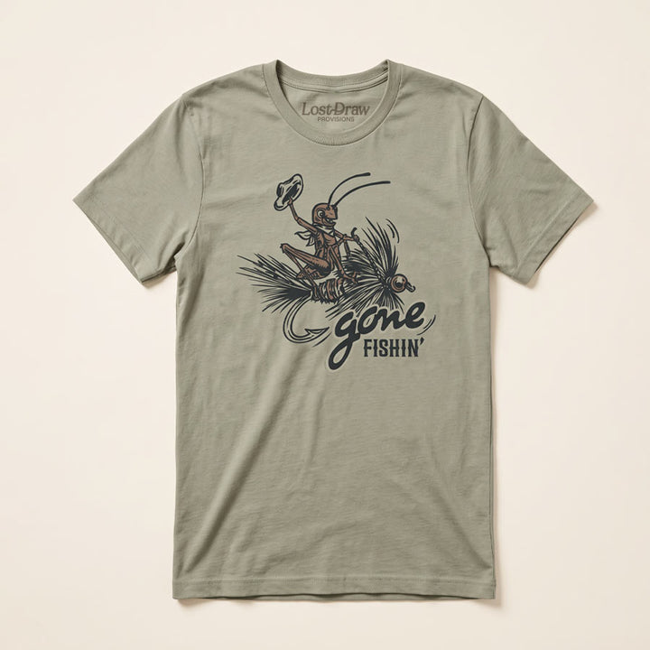 An thyme green short-sleeve t-shirt with a vintage-style graphic of a fly fisherman and the text &