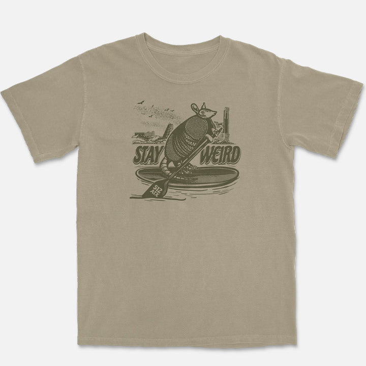 Comfort Colors Austin t-shirt featuring a vintage paddleboarding armadillo graphic with Austin skyline, bats, and “Stay Weird” lettering.