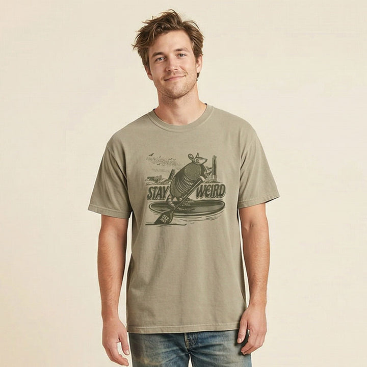 Man wearing Austin Texas armadillo paddleboarding graphic shirt with skyline and bats
