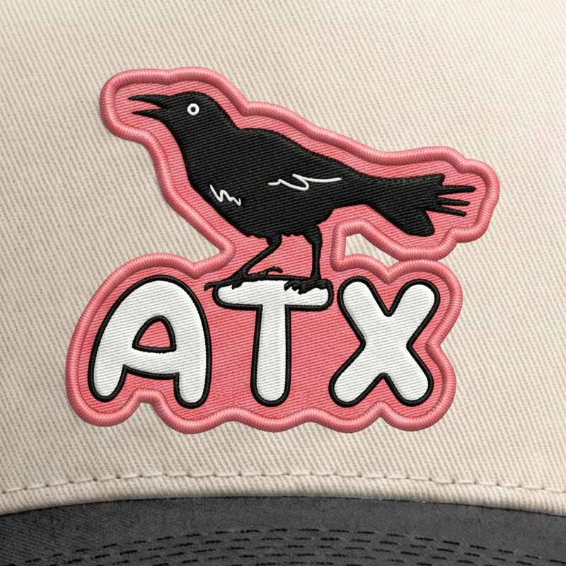 Detailed close-up of UV printed grackle patch on structured five-panel cotton twill cap