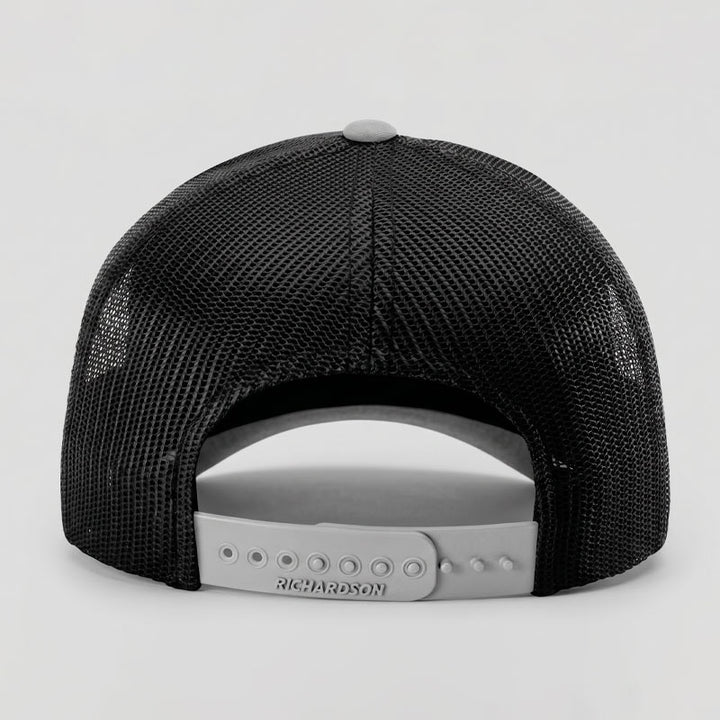 Back view of the Area 512 Richardson 112 trucker hat in black and light grey showing breathable mesh panels and adjustable snapback closure.