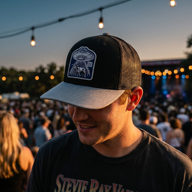 Person wearing the Area 512 Richardson 112 hat at an outdoor concert during sunset with the UFO longhorn patch prominently displayed.