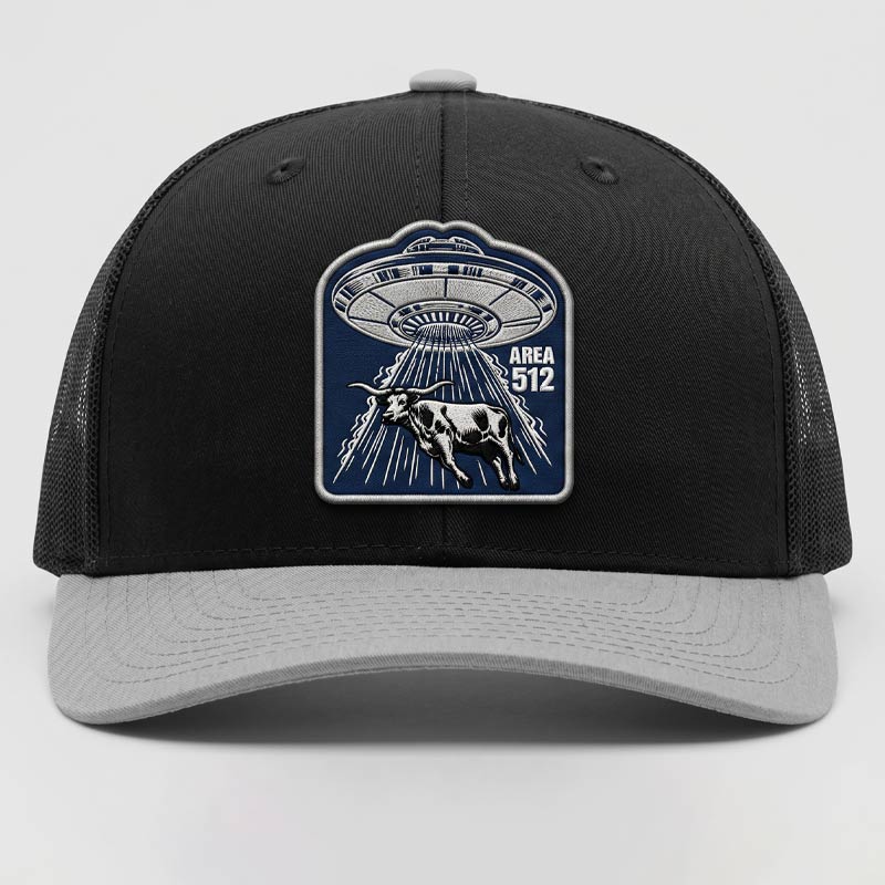 Area 512 Richardson 112 black and light grey trucker hat featuring a UFO longhorn patch with embroidered-look detail, breathable mesh back, and adjustable snapback closure.