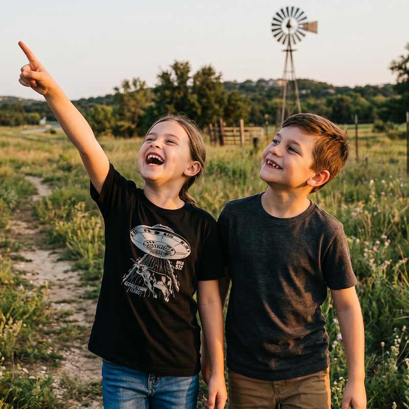 Youth wearing Georgetown Area 512 t-shirt outdoors in Georgetown, Texas with metallic silver UFO longhorn graphic on a black youth tee.