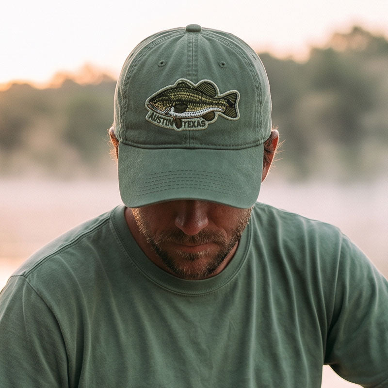 Person wearing ATX Bass Hat outdoors near a Texas lake
