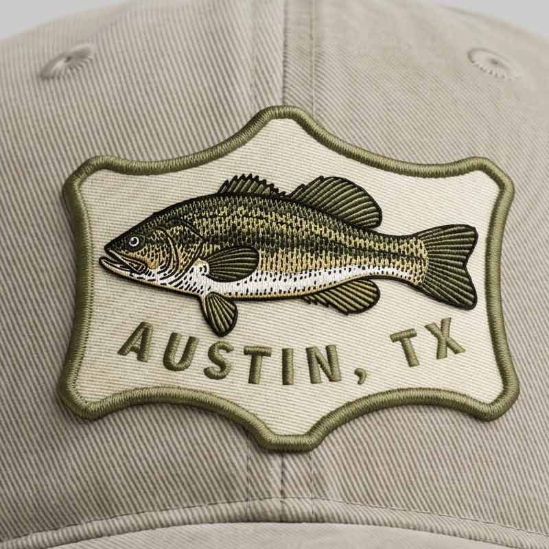 Close-up of Austin Angler Hat bass fish patch and sunwashed cotton twill texture