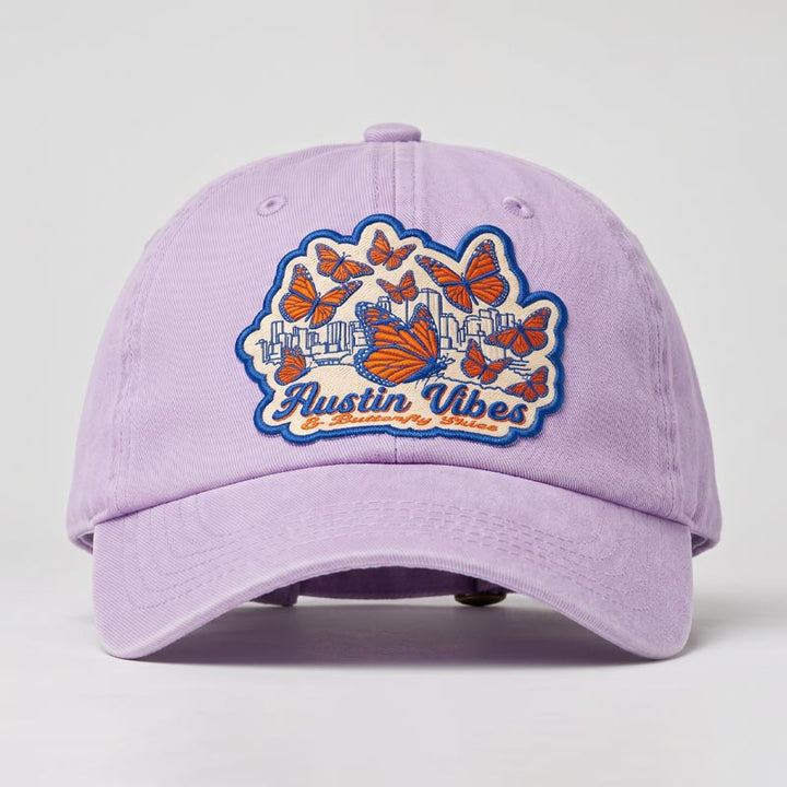 Orchid Butterfly Skies Hat featuring embroidered monarch butterfly patch and Austin skyline artwork
