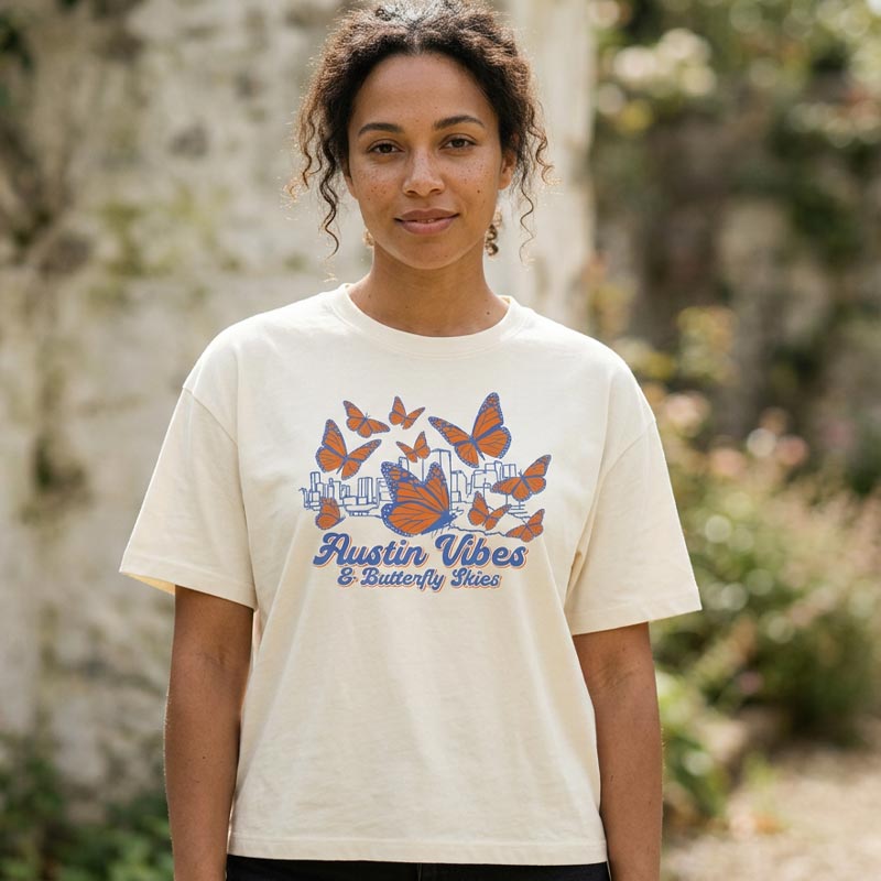 Woman wearing Butterfly Skies women’s boxy t-shirt with monarch butterflies and Austin skyline