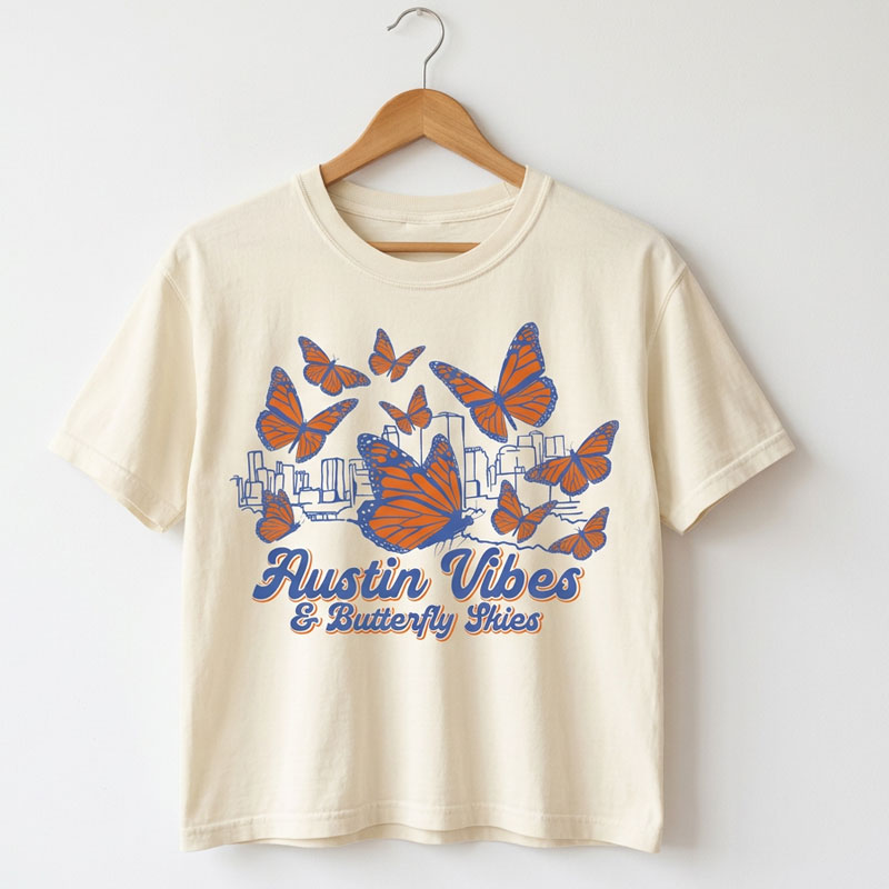 Butterfly Skies women’s heavyweight t-shirt on a hanger.