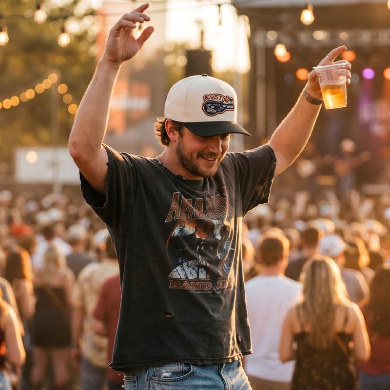 Lifestyle photo of person wearing Carry-On Austin patch hat outdoors concert at sunset in Texas