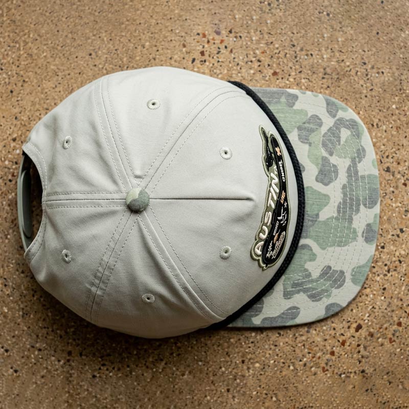 Top view of Carry-On Austin Camo Hat featuring Austin guitar case artwork on a London Fog and Duckland camo rope hat