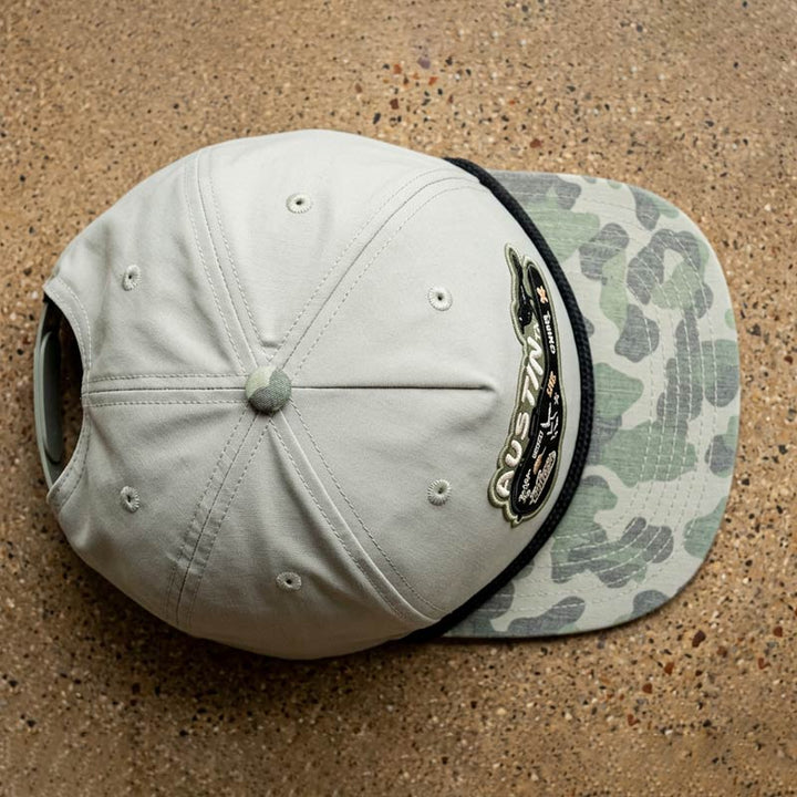 Top view of Carry-On Austin Camo Hat featuring Austin guitar case artwork on a London Fog and Duckland camo rope hat
