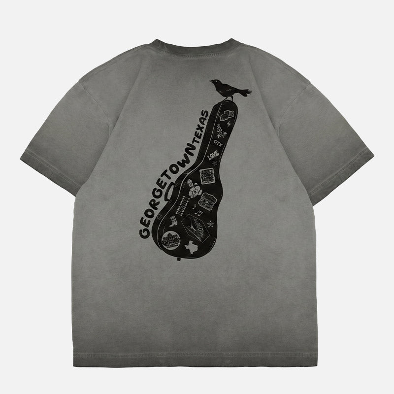 Oversized Georgetown Texas boxy t-shirt featuring a black guitar case graphic covered in Georgetown-inspired stickers with a grackle perched on top.