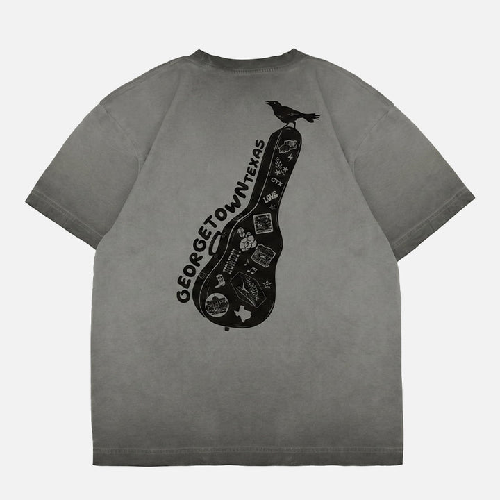Oversized Georgetown Texas boxy t-shirt featuring a black guitar case graphic covered in Georgetown-inspired stickers with a grackle perched on top.