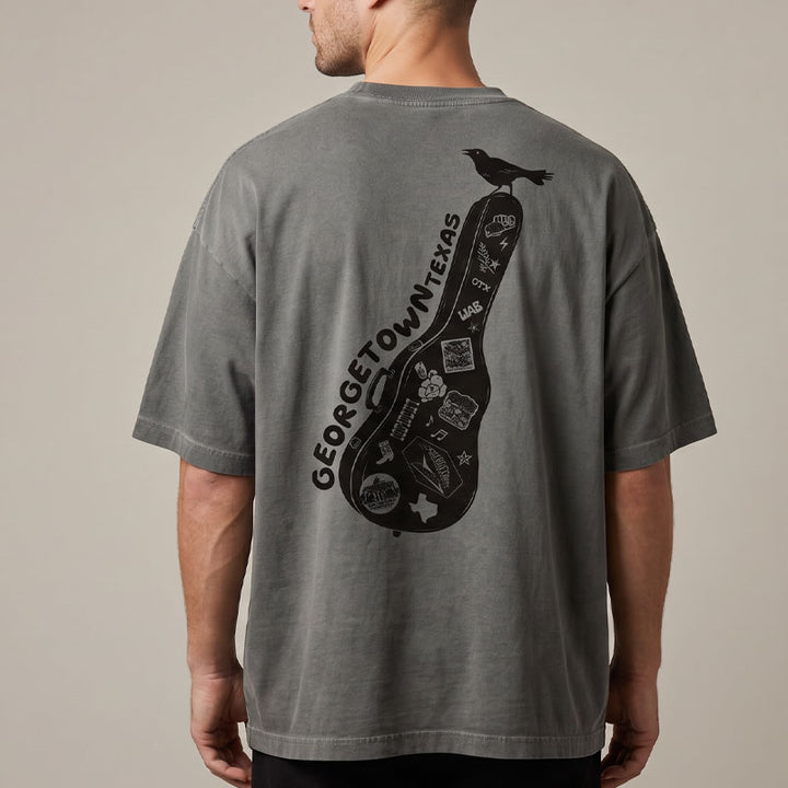 Model wearing Carry-On Georgetown oversized boxy tee in charcoal oil wash with relaxed heavyweight fit and GTX grackle graphic, back view.