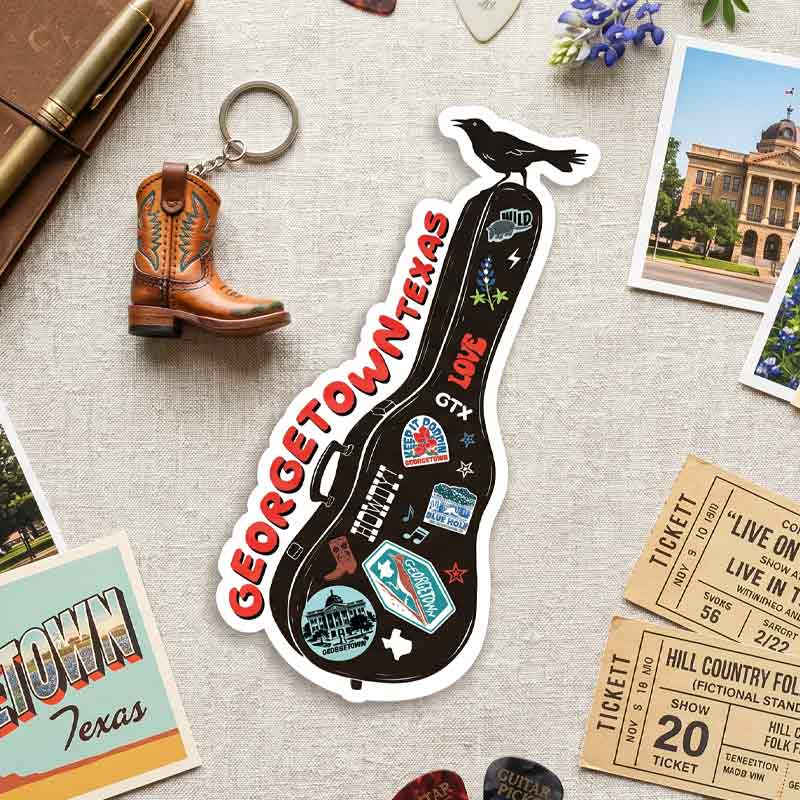 Georgetown, Texas-themed keychain and sticker on a textured surface with other items.