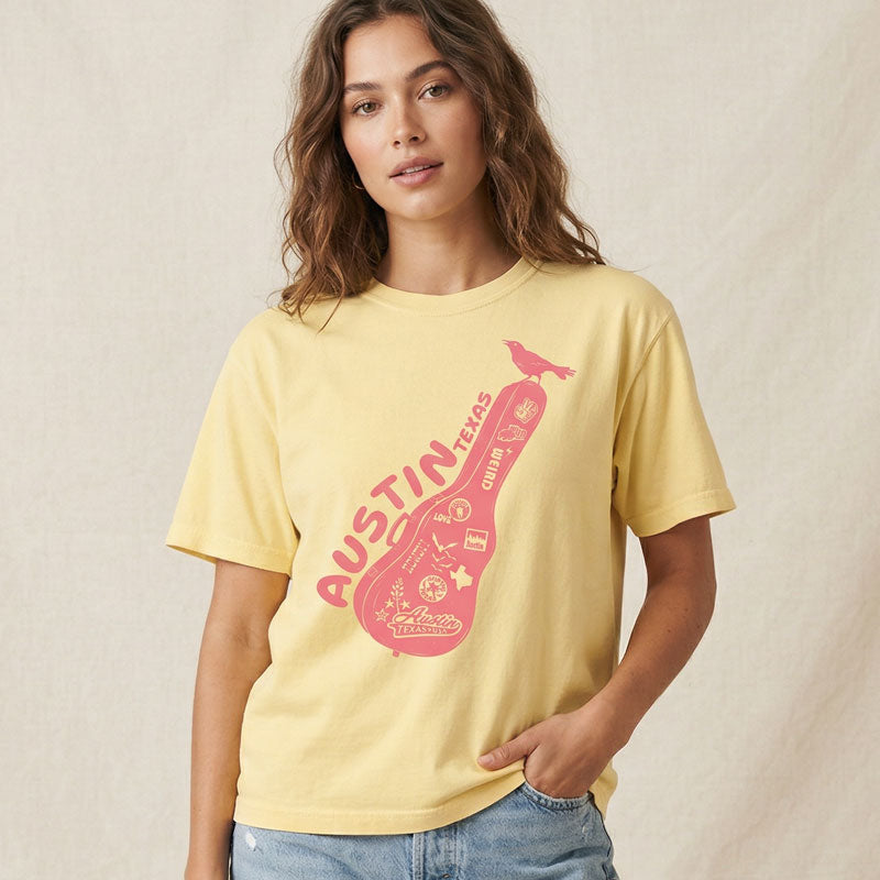 Woman wearing butter Carry-On Austin boxy t-shirt with guitar case graphic