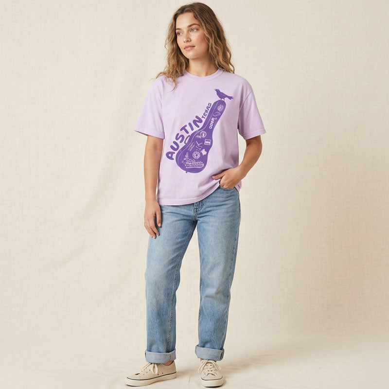 Person wearing a light purple t-shirt with a graphic design on a beige background