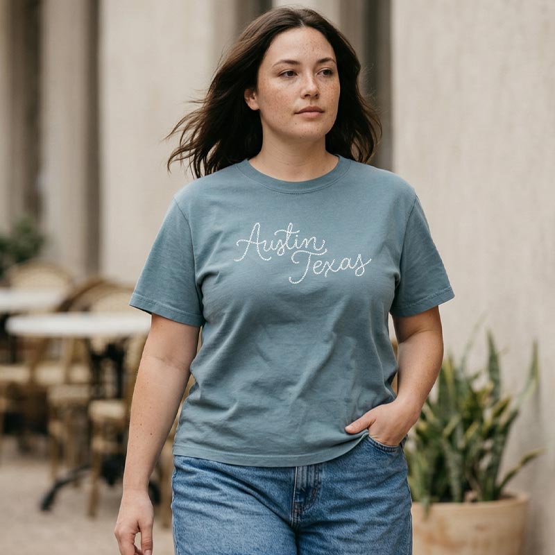 Lifestyle image of woman wearing relaxed fit Austin script tee