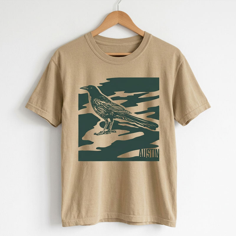 Women’s garment-dyed boxy tee in khaki with tone-on-tone green camo design on a hanger
