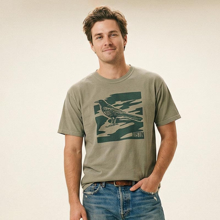 Man wearing a Austin grackle shirt with subtle camo pattern on heavyweight tee