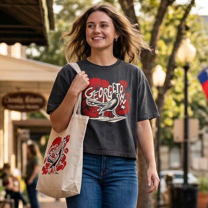 Woman wearing GTX Grackle Strut women’s garment-dyed boxy t-shirt in vintage black with bold grackle and red poppy graphic and relaxed mid-length fit