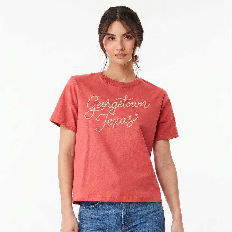 Woman wearing Georgetown Texas women’s boxy t-shirt in garment-dyed red with vintage chainstitch-style script graphic and relaxed cropped fit