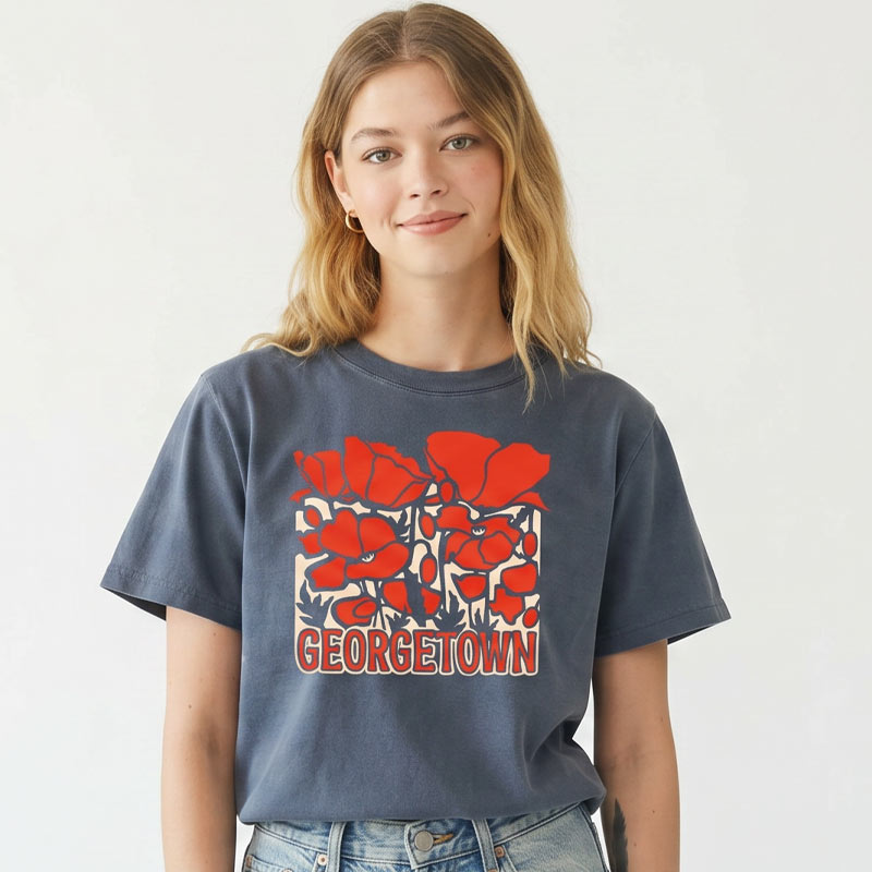 Woman wearing Georgetown Texas women’s boxy t-shirt in garment-dyed navy with bold red poppy graphic and relaxed cropped fit