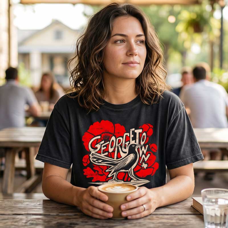 Woman wearing black Grackle Strut Georgetown shirt outdoors in Central Texas near downtown square