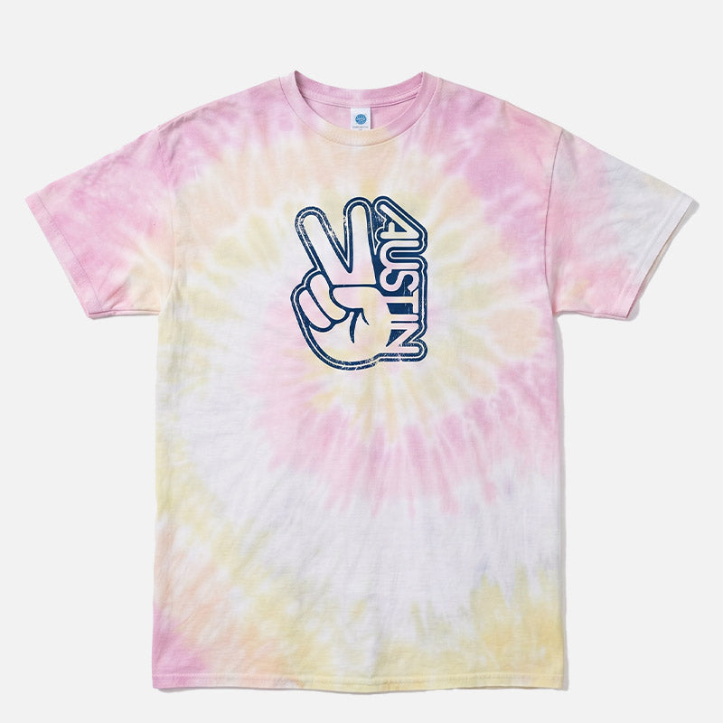 Groovy Austin tie-dye t-shirt in Desert Rose featuring a distressed navy Austin peace sign graphic on a pink, cream, and soft yellow Colortone tie-dye unisex tee.